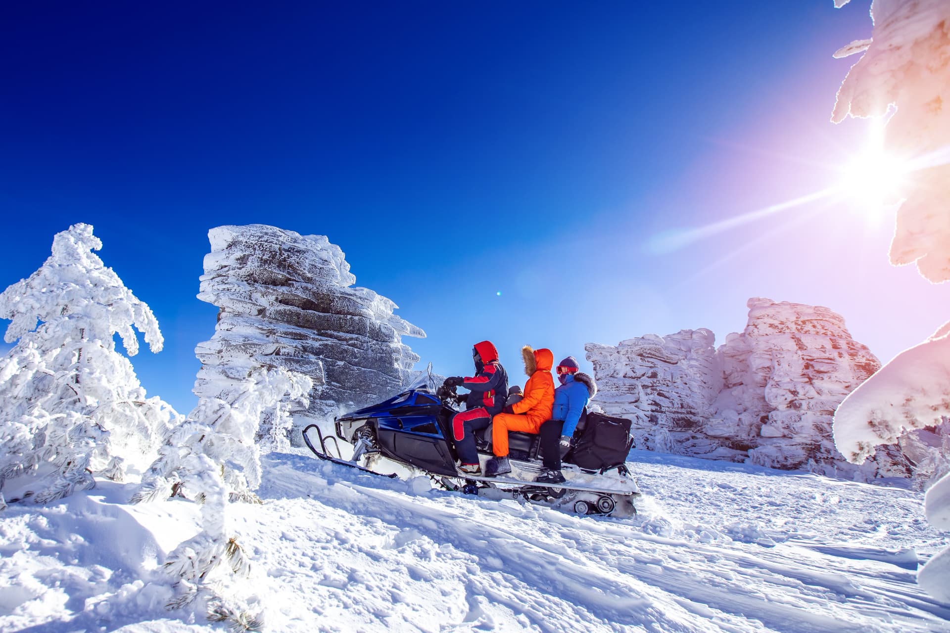 Guests riding snowmobiles through a frozen mountain pass